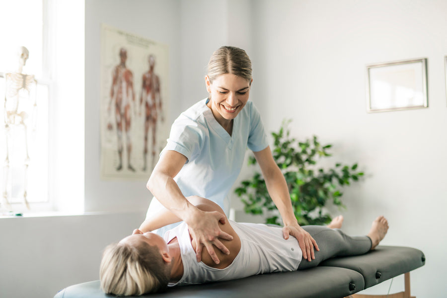 A chiropractor working with a client on a treatment table